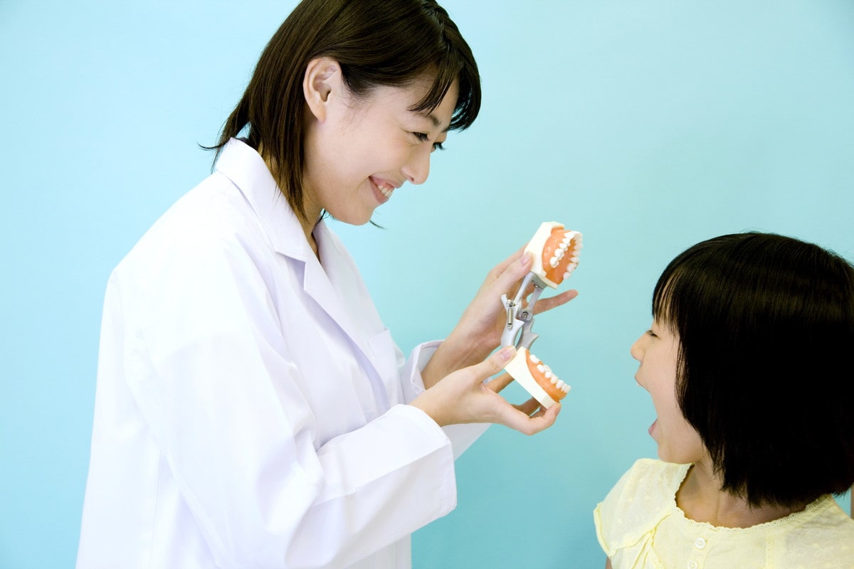 子供に歯の矯正について説明する先生