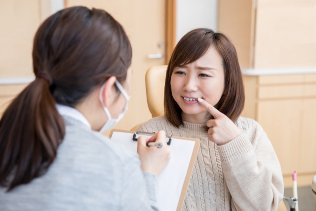 【高松 歯科】ホワイトニングの費用相場解説 歯を指さす女性